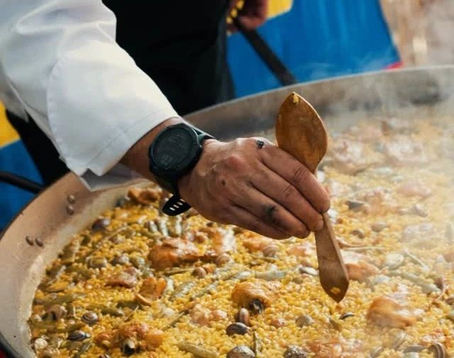 Chef sirviendo paella a invitados